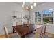 Charming dining room features a wooden table, stylish chairs, contemporary chandelier, and a large window for natural light at 3328 Flamingo Ave, Charlotte, NC 28205