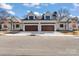 Charming new construction duplex featuring white brick and wooden garage doors, with well-maintained landscaping at 3328 Flamingo Ave, Charlotte, NC 28205