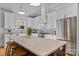 Spacious kitchen with stainless steel appliances, white cabinetry, a large center island, and modern pendant lighting at 3328 Flamingo Ave, Charlotte, NC 28205