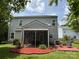 Backyard with a screened-in porch, brick patio, and lush green lawn, surrounded by mature trees and landscaping at 3500 Exbury Gardens Dr, Waxhaw, NC 28173