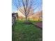 Picturesque backyard with mature trees, lush green grass, and a brick patio at 3500 Exbury Gardens Dr, Waxhaw, NC 28173