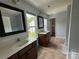 Bright primary bathroom with tile floor, dual sinks, framed mirrors, and lots of natural light at 3500 Exbury Gardens Dr, Waxhaw, NC 28173