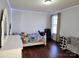 Cozy bedroom featuring hardwood floors, an adjacent desk, and a comfortable sitting area at 3500 Exbury Gardens Dr, Waxhaw, NC 28173