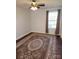 Bedroom with wood floors, a ceiling fan, and large window with dark curtains at 3500 Exbury Gardens Dr, Waxhaw, NC 28173