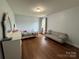 Bedroom featuring hardwood floors, a bed, dresser, and light gray sofa at 3500 Exbury Gardens Dr, Waxhaw, NC 28173