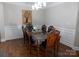 Elegant dining room with dark hardwood floors, wainscoting, chandelier, and a large wood table with seating for eight at 3500 Exbury Gardens Dr, Waxhaw, NC 28173