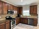 Bright kitchen with stainless steel appliances, dark wood cabinets, and a functional layout at 3500 Exbury Gardens Dr, Waxhaw, NC 28173