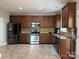 Modern kitchen featuring stainless steel appliances, dark wood cabinets, and ample counter space at 3500 Exbury Gardens Dr, Waxhaw, NC 28173