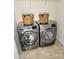 Laundry room showcasing a side-by-side washer and dryer set with two wicker baskets on top and tile flooring at 3500 Exbury Gardens Dr, Waxhaw, NC 28173