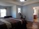 This main bedroom features hardwood flooring, a ceiling fan, and is naturally lit with a large window at 3500 Exbury Gardens Dr, Waxhaw, NC 28173