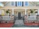 Inviting front porch with stone accents, ceiling fans, and beautiful landscaping at 369 Shoreline Pkwy, Tega Cay, SC 29708