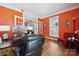 Bright home office with orange walls, white trim, hardwood floors, and plenty of natural light at 369 Shoreline Pkwy, Tega Cay, SC 29708