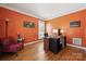 Office space with an orange accent wall, hard wood floors, and a comfortable chair at 369 Shoreline Pkwy, Tega Cay, SC 29708