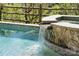 Close-up of a pool waterfall feature with stone accents and lush landscaping at 369 Shoreline Pkwy, Tega Cay, SC 29708