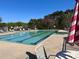 Outdoor community pool with lounge chairs and shade umbrellas on a sunny day at 4095 Harmattan Dr, Denver, NC 28037