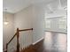Bright hallway featuring hardwood floors, staircase with white banister, and natural light at 4095 Harmattan Dr, Denver, NC 28037