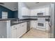 Close-up of a well-lit kitchen with white cabinets, black countertops, and stainless steel appliances at 4677 Arthur Way, Rock Hill, SC 29732