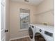 Bright laundry room with large washer and dryer, window and ample storage shelving at 4677 Arthur Way, Rock Hill, SC 29732