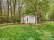View of shed featuring a garage door surrounded by lush greenery and a fence at 4677 Arthur Way, Rock Hill, SC 29732