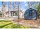 Backyard featuring home, patio, storage building, and well-manicured lawn at 5009 Milford Rd, Charlotte, NC 28210