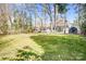 Large backyard featuring mature trees, grassy lawn, and storage building at 5009 Milford Rd, Charlotte, NC 28210