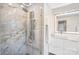 Elegant bathroom featuring marble walk-in shower, sleek vanity, and a modern, illuminated mirror at 5009 Milford Rd, Charlotte, NC 28210