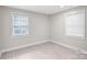 Neutral bedroom featuring hardwood floors, natural light, and two windows with blinds at 5009 Milford Rd, Charlotte, NC 28210