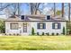 Charming white brick home with black shutters, well-manicured lawn and a modern glass door at 5009 Milford Rd, Charlotte, NC 28210