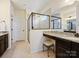 Bright primary bathroom featuring a granite vanity, tiled shower, and decorative stool at 5059 Saint Clair St, Fort Mill, SC 29715
