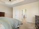 Neutral toned main bedroom with a tray ceiling, carpet flooring, and ensuite bath at 5059 Saint Clair St, Fort Mill, SC 29715