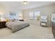 Bright bedroom with a large window, cozy bed, vanity and natural light, creating a serene atmosphere at 5059 Saint Clair St, Fort Mill, SC 29715