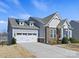 Charming home with a two-car garage, stone accents, and well-manicured landscaping, showcasing curb appeal at 5059 Saint Clair St, Fort Mill, SC 29715
