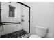 Modern bathroom features glass-enclosed shower with black fixtures and tiled floors at 5616 Ebley Ln, Charlotte, NC 28227