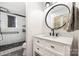 Modern bathroom with shower, vanity, a round mirror, and black fixtures at 5616 Ebley Ln, Charlotte, NC 28227