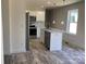 Bright kitchen boasts stainless steel appliances, white cabinets, and a stylish island with marble countertops at 565 Perry Rd, Troutman, NC 28166