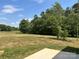 Expansive backyard featuring green grass and mature trees at 565 Perry Rd, Troutman, NC 28166