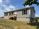 Home with gray siding, black shutters, wooden deck, and a partially finished basement at 565 Perry Rd, Troutman, NC 28166