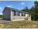 Charming home featuring gray siding, black shutters and well-maintained landscaping at 565 Perry Rd, Troutman, NC 28166