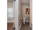Neutral bathroom features a toilet, gray floors, natural lighting, and access to another room at 634 Carolina Ave, Gastonia, NC 28052