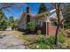 Exterior view of property with mature trees, brick chimney, and colorful landscaping at 634 Carolina Ave, Gastonia, NC 28052