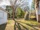 Lush backyard featuring a storage shed, access to a deck with stairs, and mature trees providing ample shade at 707 Oakshade Ave, Kannapolis, NC 28083
