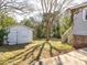 Spacious backyard featuring a storage shed, access to a deck with stairs, and mature trees providing ample shade at 707 Oakshade Ave, Kannapolis, NC 28083