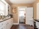Well-lit kitchen features white cabinets, laminate countertops, window, and offers access to the laundry room at 707 Oakshade Ave, Kannapolis, NC 28083