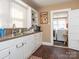 Bright kitchen with white cabinets, laminate countertops, a view of the laundry room, and a functional layout at 707 Oakshade Ave, Kannapolis, NC 28083
