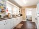 Functional kitchen with white cabinetry, laminate countertops, window, and views into the laundry room at 707 Oakshade Ave, Kannapolis, NC 28083