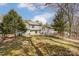 Large backyard with mature trees, a fire pit, and a spacious lawn for outdoor enjoyment at 7815 Ambleside Dr, Charlotte, NC 28216