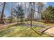 Spacious backyard with a cozy fire pit area, swing set, and ample space for recreation at 7815 Ambleside Dr, Charlotte, NC 28216