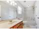 Bright bathroom with a large vanity, updated fixtures, a window, and a shower-tub combo at 7815 Ambleside Dr, Charlotte, NC 28216