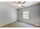 Bright bedroom with plush carpet, featuring a ceiling fan and a window providing natural light at 7815 Ambleside Dr, Charlotte, NC 28216