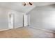 Spacious bedroom featuring neutral walls, plush carpet, ceiling fan, and access to an ensuite bathroom at 7815 Ambleside Dr, Charlotte, NC 28216